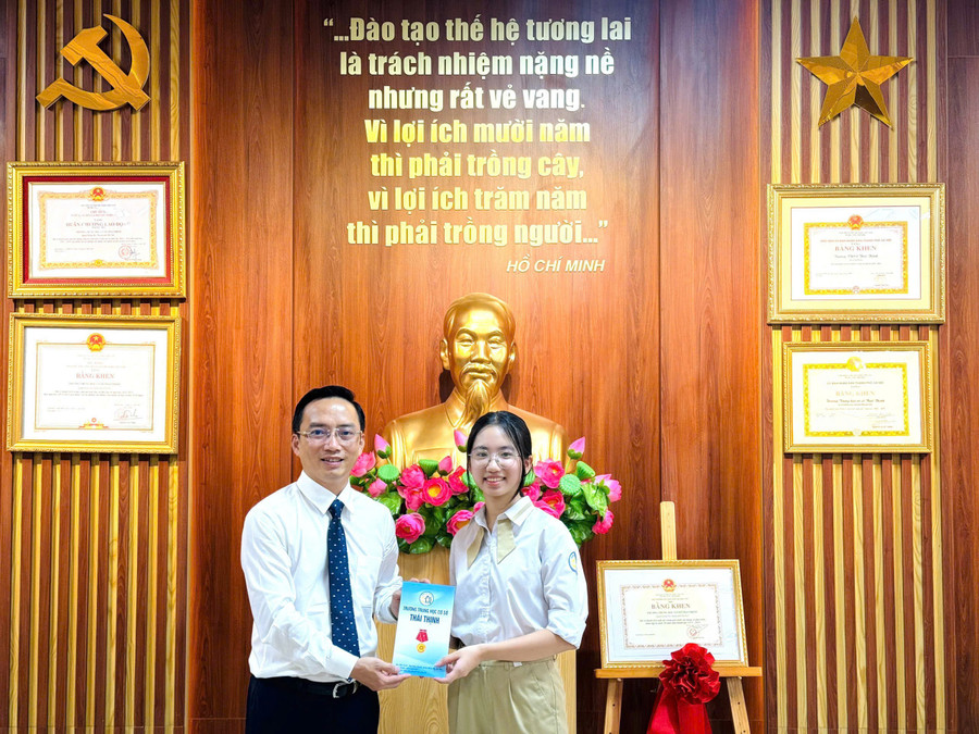Hiệu trưởng Nguyễn Cao Cường trao thưởng cho em Nguyễn Hà My - đạt tổng điểm thi vào lớp 10 cao nhất trường năm 2025. Ảnh: NTCC.