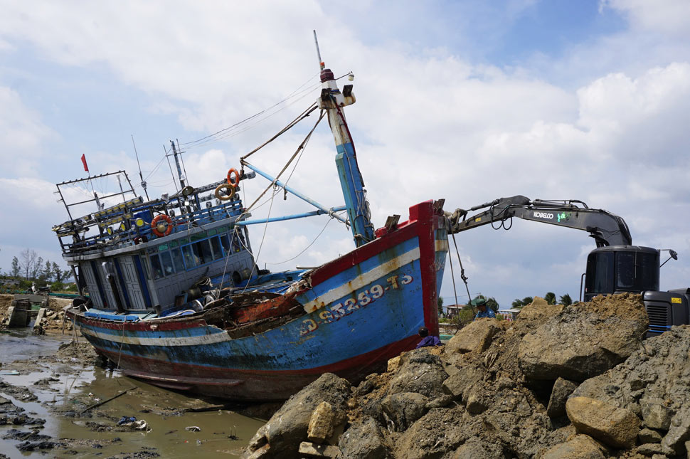 Ngư dân thuê máy múc để giải cứu tàu mắc cạn. Ảnh: Hoài Phương