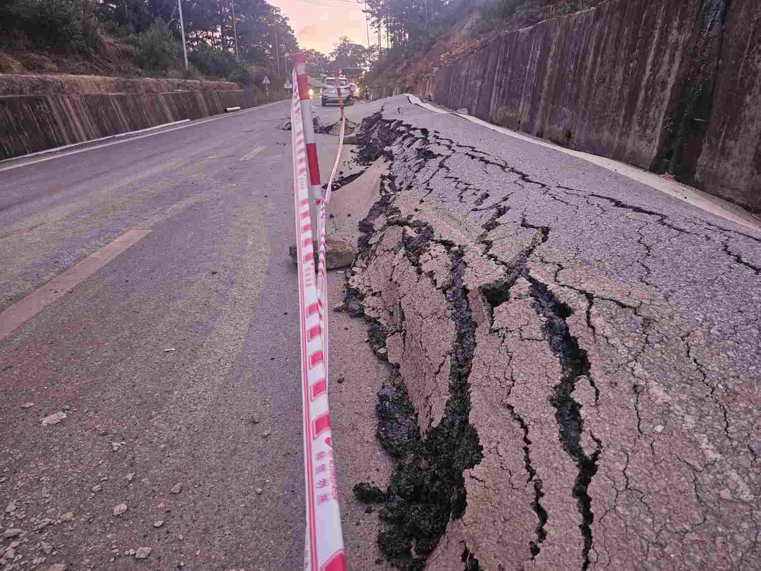 Mặt QL 24 bị đùn cao lên bất thường do ảnh hưởng sạtt lở từ ta luy dương. Ảnh: Nguyễn Thanh