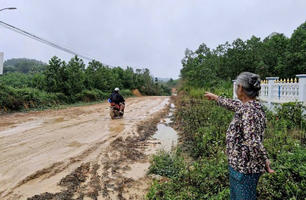 Người dân bức xúc trước cảnh tuyến đường lầy lội bùn đất. Ảnh: Quách Du