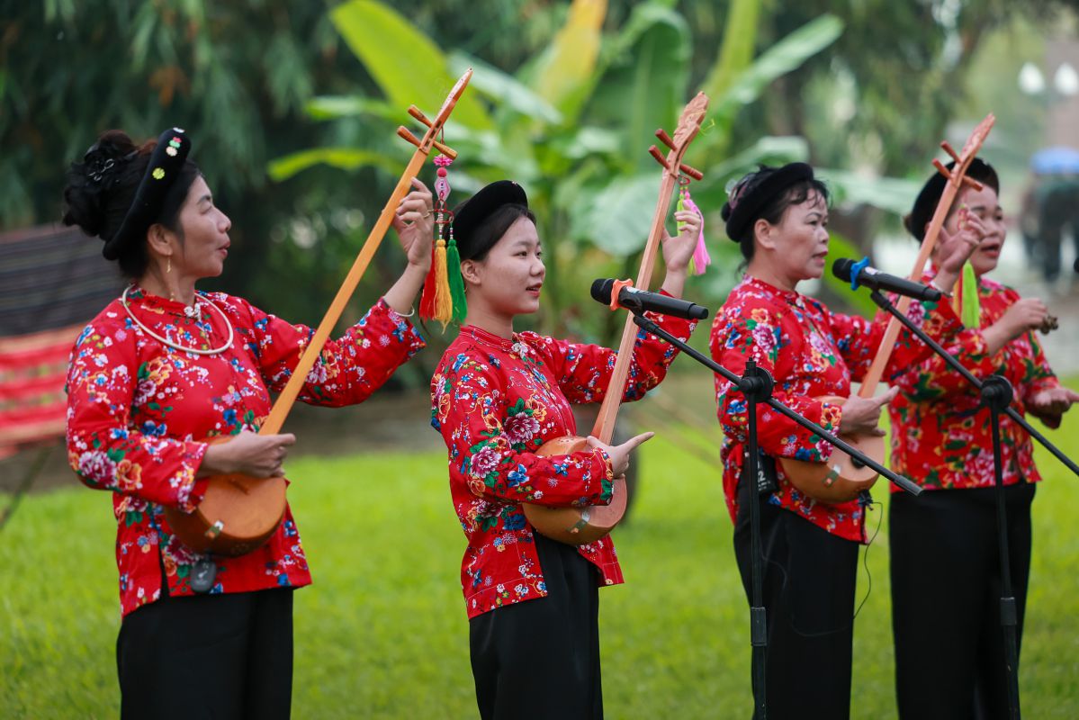 Người dân tộc Nùng trong trang phục hoa đào truyền thống, cầm đàn tính biểu diễn tại “Ngày hội văn hóa các dân tộc“. Ảnh: Hải Nguyễn