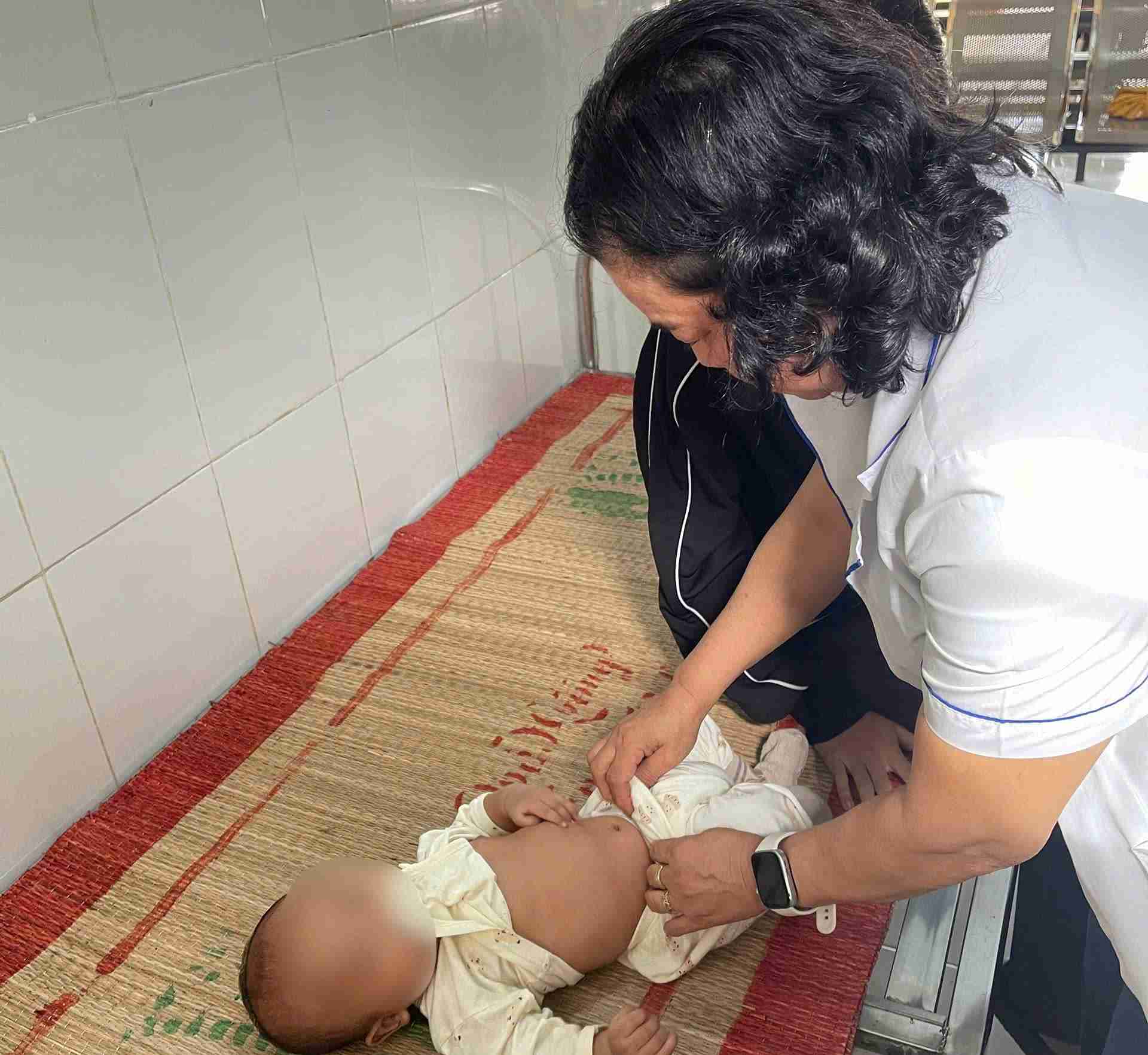 Nhân viên trạm y tế xã khám sức khỏe cho trẻ. Ảnh: Bảo Lâm