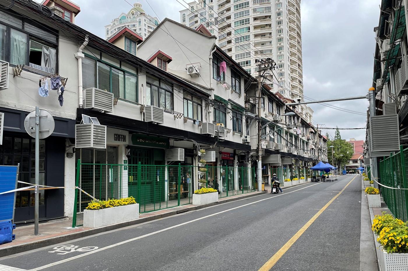 Hàng rào xanh phong tỏa lối vào các cửa hàng và khu dân cư dọc một con phố tại Thượng Hải hôm 24/4. Ảnh: Reuters.
