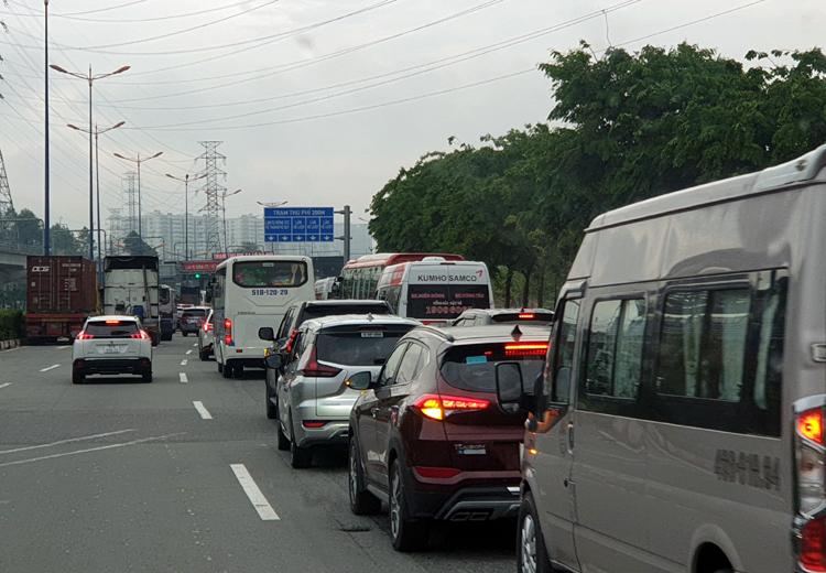 Ô tô xếp hàng dài qua trạm thu phí Xa lộ Hà Nội trong buổi sáng.