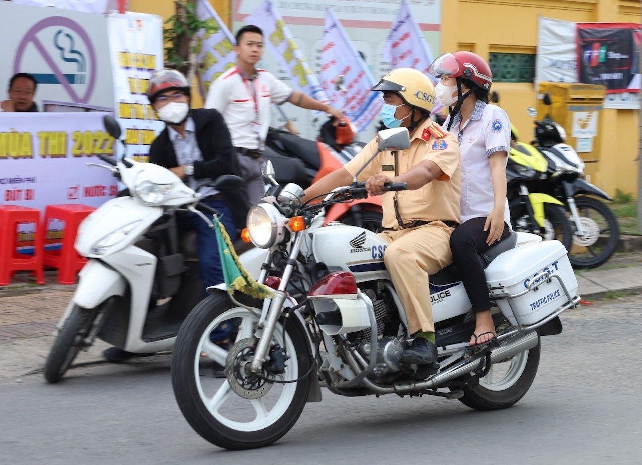 Thiếu tá CSGT chở nữ sinh về nhà lấy giấy báo dự thi và quay trở lại điểm thi an toàn. Ảnh: Minh Anh.