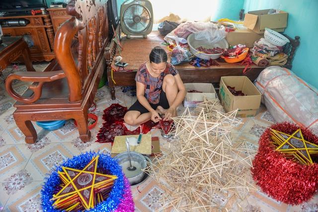 Tại gia đình ông Trận mỗi người làm một công đoạn, trong đó con trai thì sơn, phơi cán đèn còn vợ dán giấy bóng và trang trí.