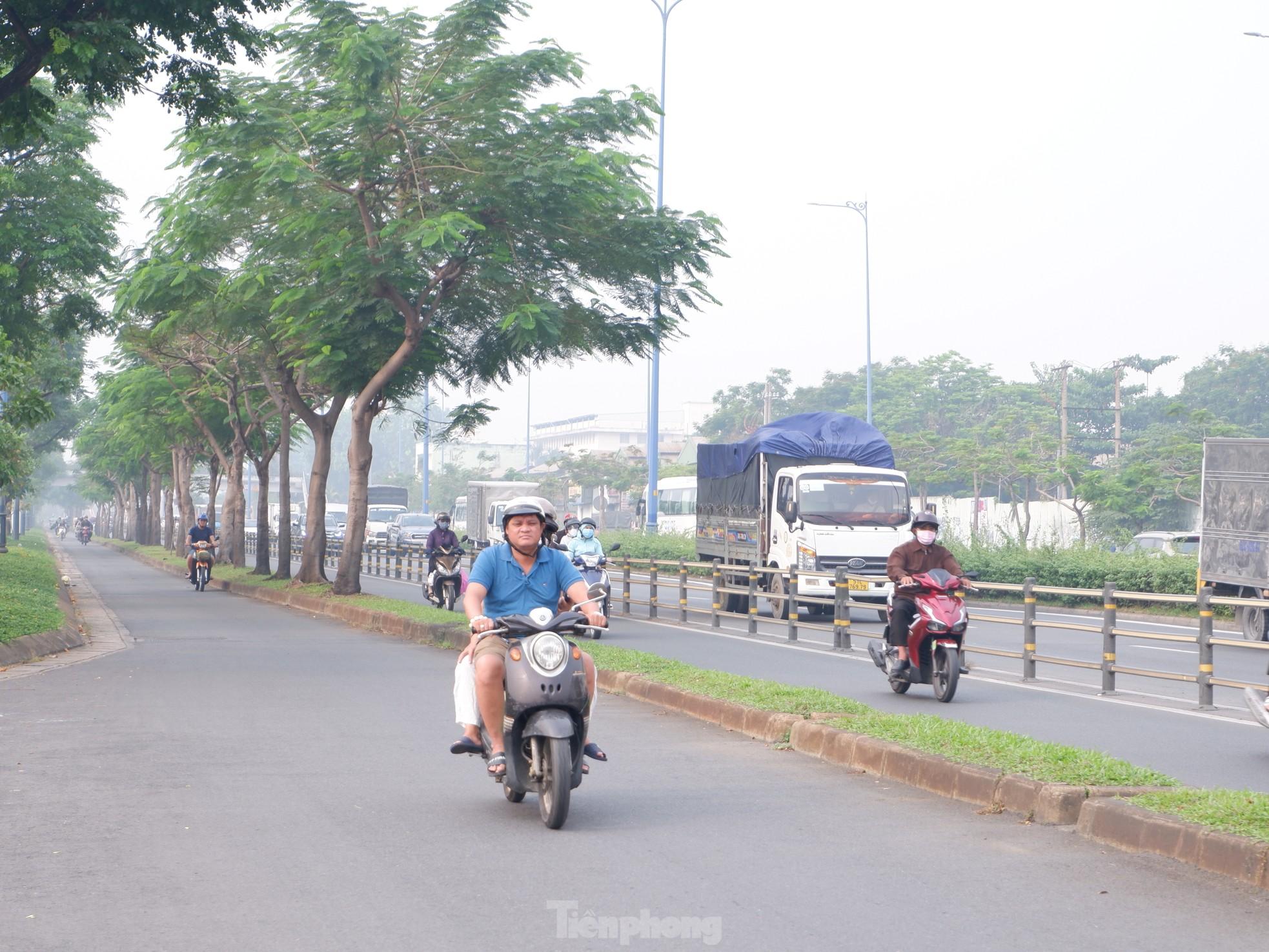 Hình ảnh sương mù sáng nay ở TPHCM, nồng độ bụi mịn vượt mức cho phép hàng chục lần - Ảnh 1.