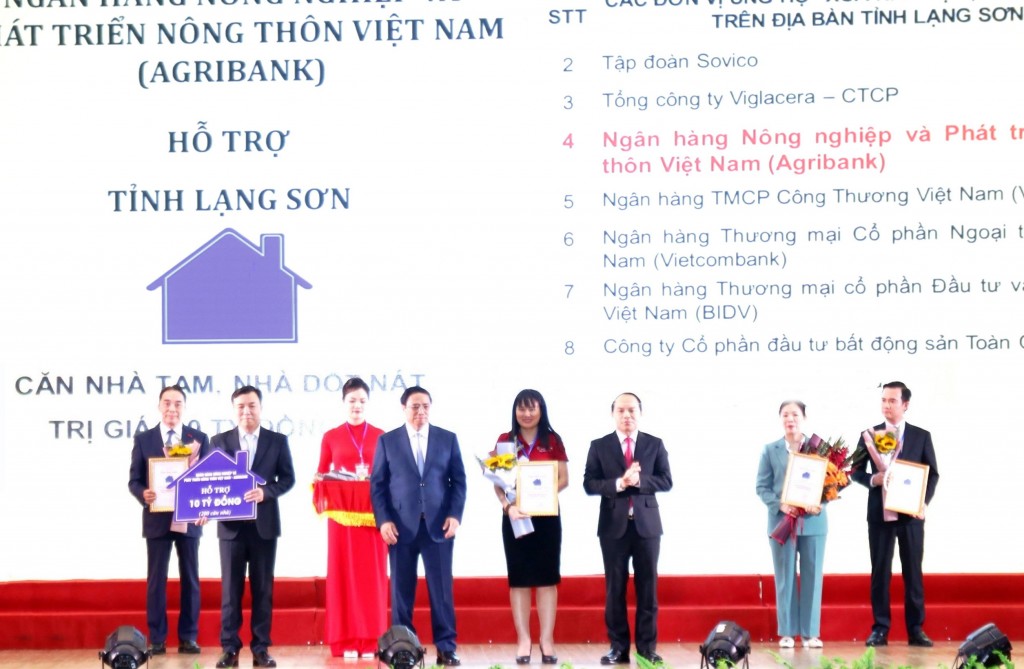 Đại diện Agribank  - Đ/c Phùng Thị Bình Phó Tổng Giám đốc (thứ 5 từ trái sang) trao biểu trưng tài trợ 10 tỷ đồng