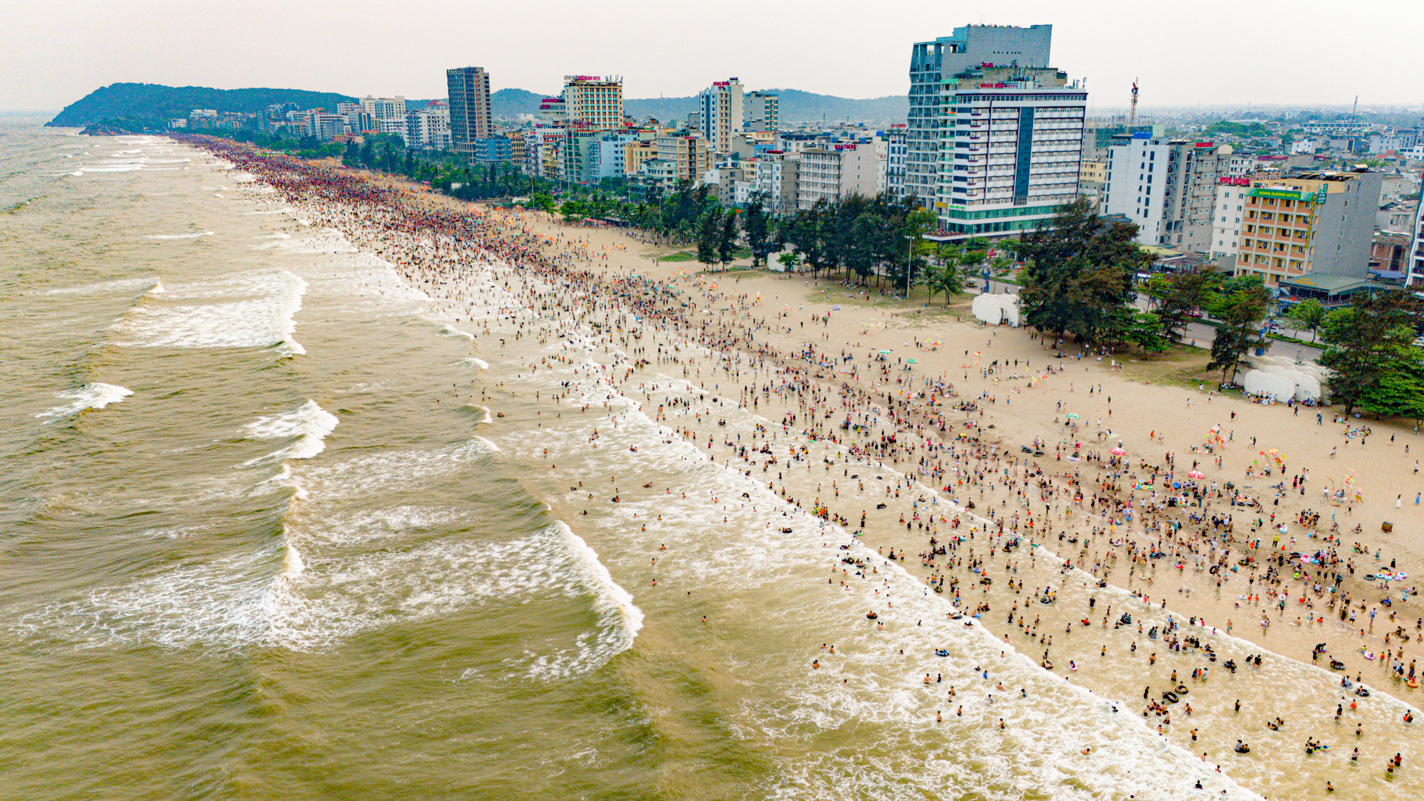 Bãi biển Sầm Sơn ken đặc người đổ về giải nhiệt, du khách nói 3 lý do quyết lựa chọn nơi này- Ảnh 1.