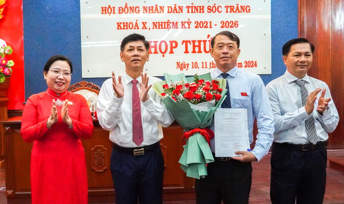 Ông Lâm Văn Mẫn - Ủy viên Ban chấp hành Trung ương Đảng, Bí thư Tỉnh ủy Sóc Trăng cùng Lãnh đạo Tỉnh ủy, UBND tỉnh trao quyết định và tặng hoa chúc mừng ông Nguyễn Văn Khởi. Ảnh: Phương Anh