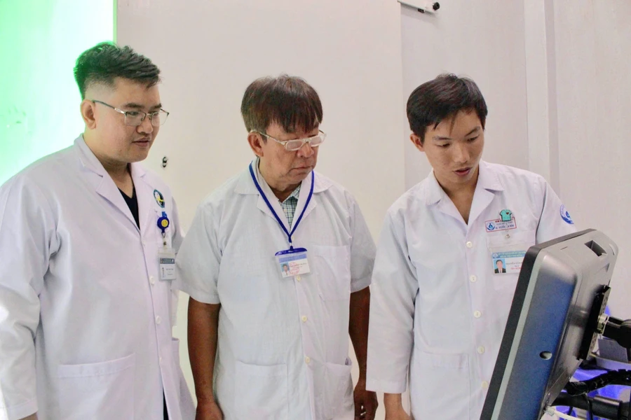 BS Luân Thanh Trường - Trưởng Trạm Y tế xã Thạnh An cùng các bác sĩ đọc kết quả chụp máy X-quang có tích hợp AI. Ảnh: L.N