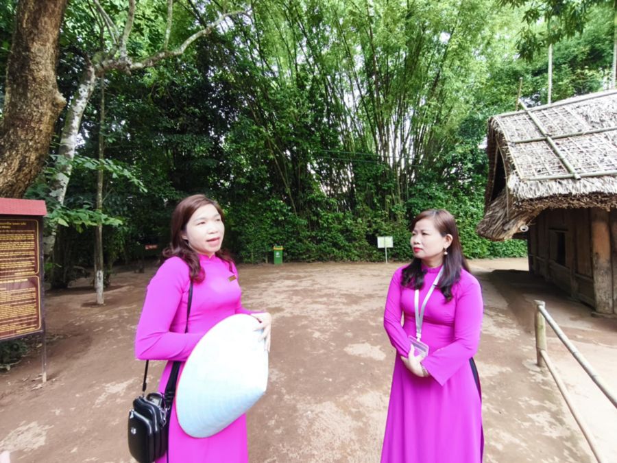 Hướng dẫn viên Lê Thị Hà (bìa phải)  và Nguyễn Thị Thanh (bìa trái) tại di tích nhà quê nội Bác Hồ. Ảnh: Quang Đại
