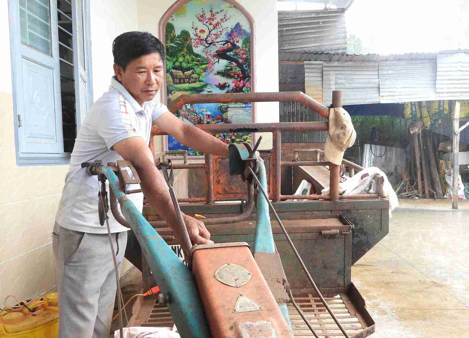 Anh Phạm Ngọc Vinh bên chiếc xe công nông một trong những phương tiện giúp anh thoát nghèo. Ảnh: Bảo Trung