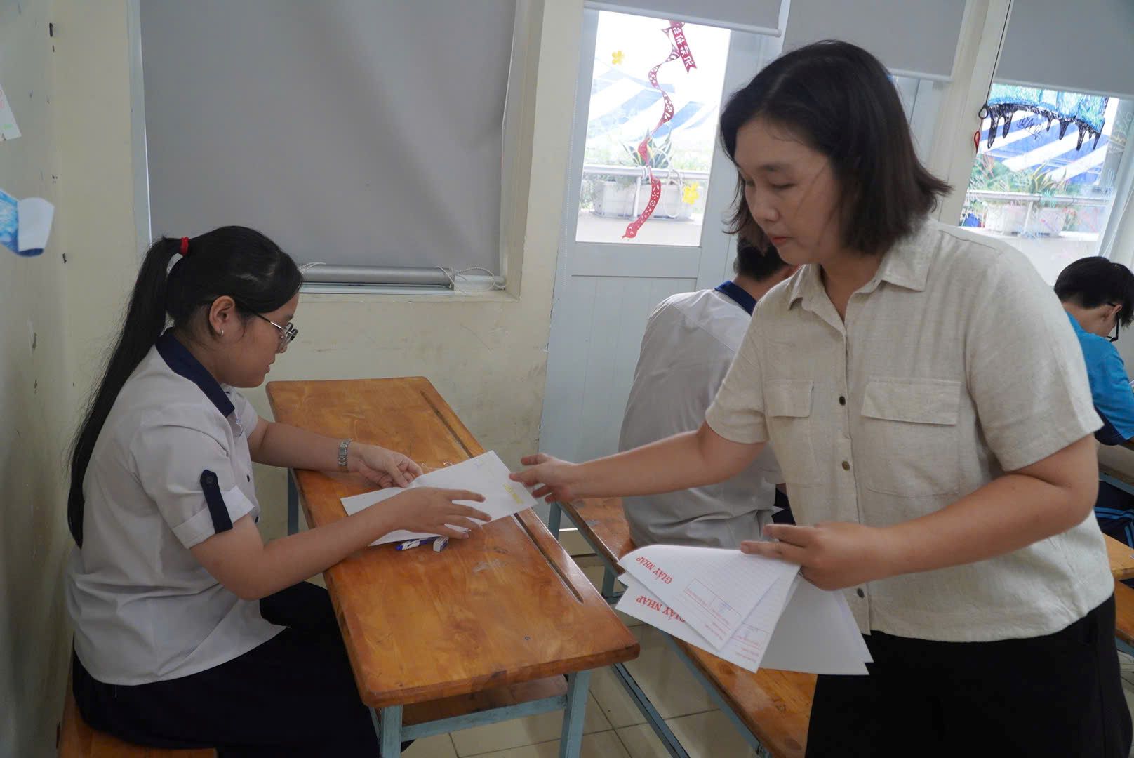 Giám thị phát giấy thi cho thí sinh. Ảnh: Chân Phúc