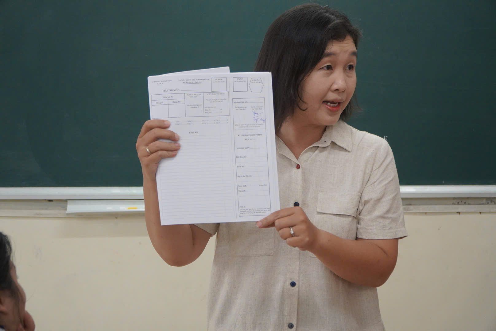 Giám thi coi thi hướng dẫn điền thông tin trên giấy thi cho thí sinh. Ảnh: Chân Phúc