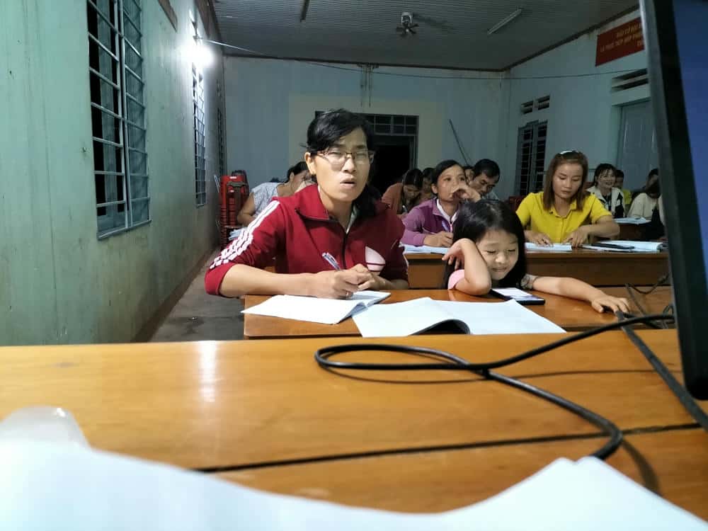 Tranh thủ cùng con tham gia lớp học nghề vào ban đêm, sau giờ làm nương rẫy. Ảnh: Bảo Lâm
