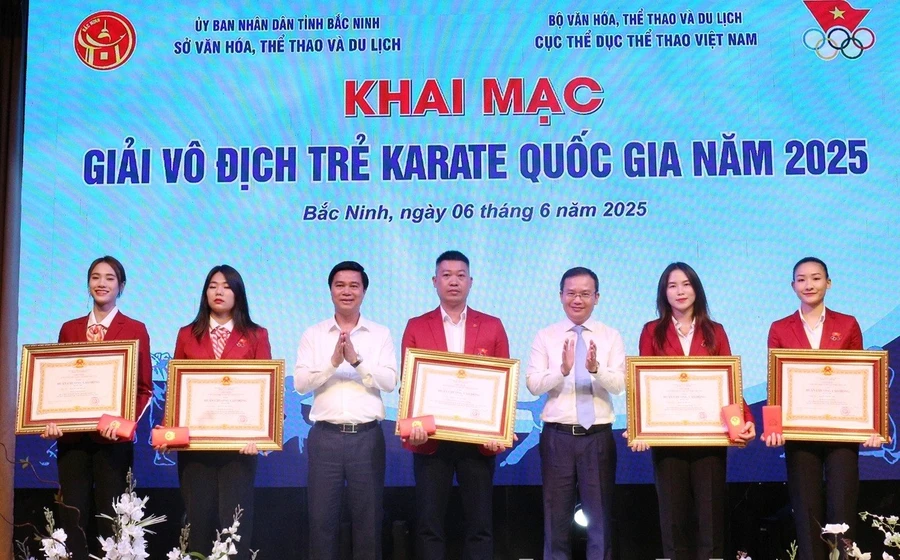 Thừa ủy quyền, Phó Chủ tịch UBND tỉnh Bắc Ninh Lê Xuân Lợi (thứ 3 từ trái qua) trao Huân chương Lao động hạng Nhì cho các HLV, VĐV đội tuyển Karate Quốc gia đạt thành tích xuất sắc.