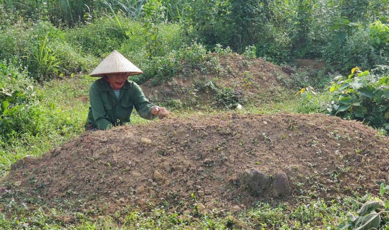 Bà Phạm Thị Tiến bật khóc khi thăm mộ con và lo sợ nguồn nước ngầm ô nhiễm, ảnh hưởng đến các ngôi mộ người đã khuất. Ảnh: Minh Hoàng