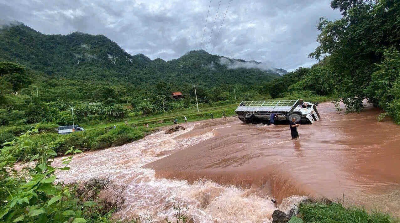 Một ô tô bị lật nghiêng khi cố đi qua dòng nước lũ tại xã Na Loi (huyện Kỳ Sơn cũ). Ảnh: Hải Đăng