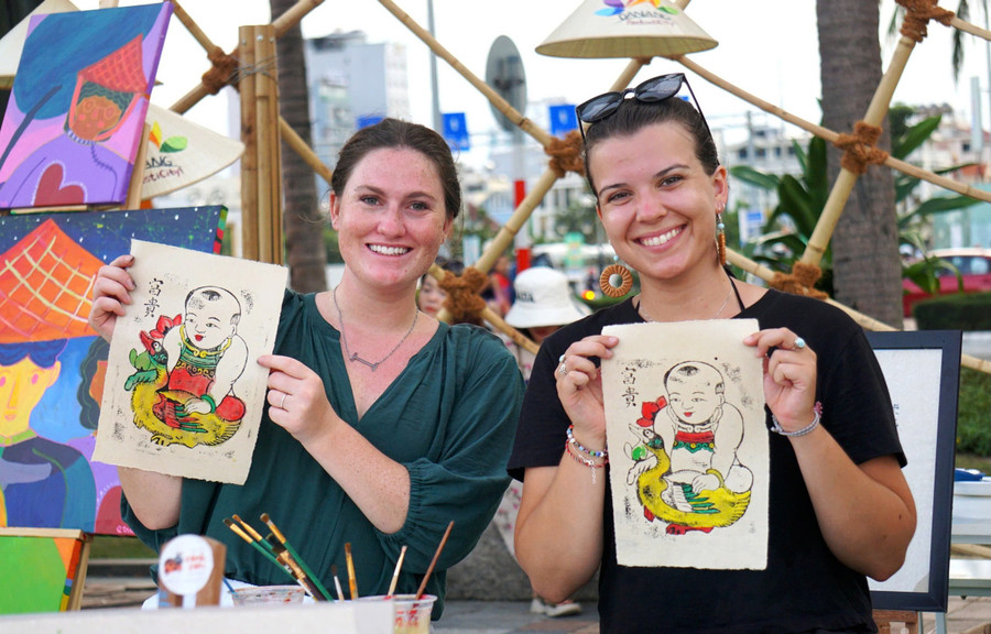 Du khách hào hứng khi trải nghiệm làm tranh Đông Hồ trên giấy dó. Ảnh: INT.