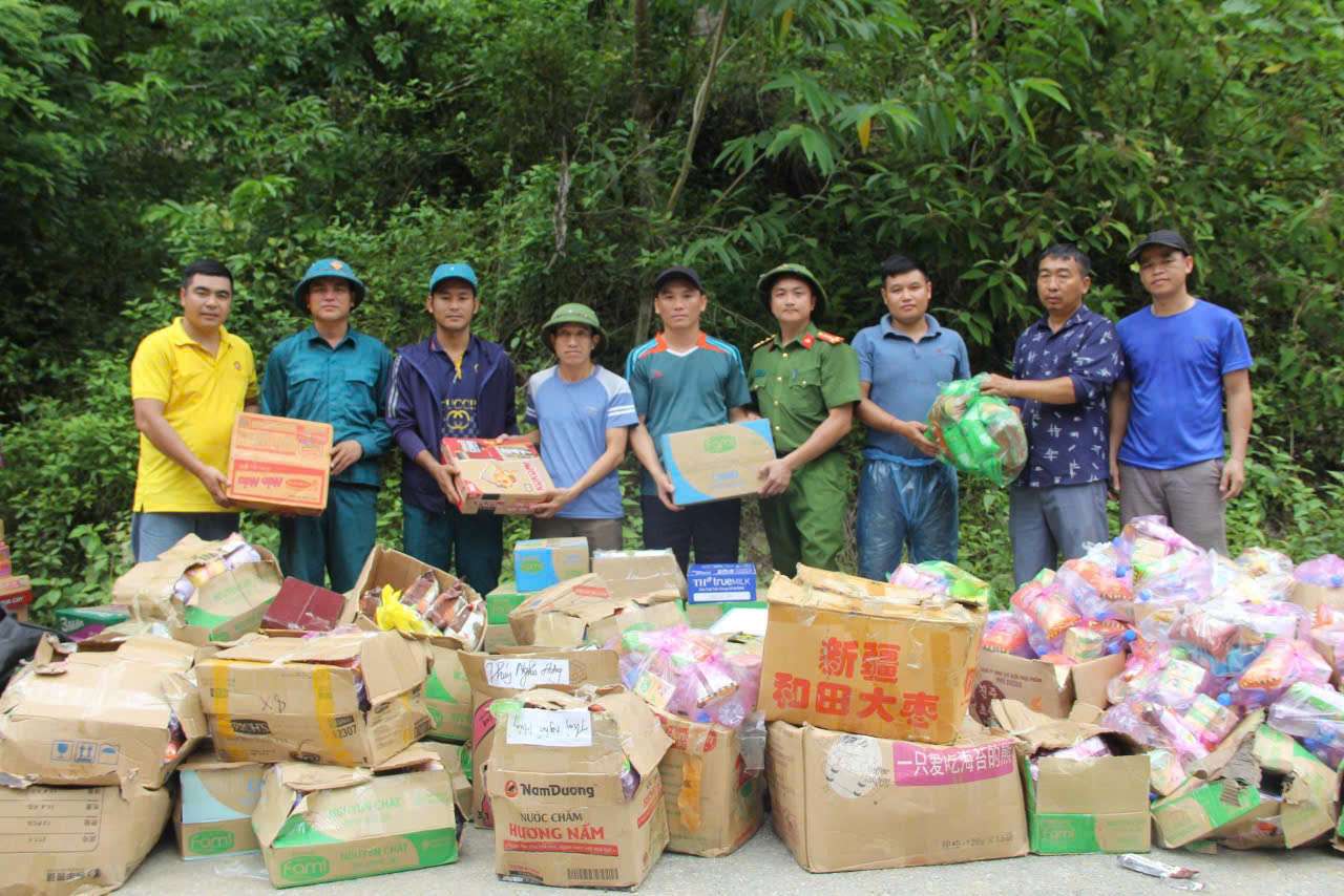 Cán bộ địa phương tổ chức trao hàng tiếp tế cho bà con ngay bên bờ sông. Ảnh: Phạm Chung