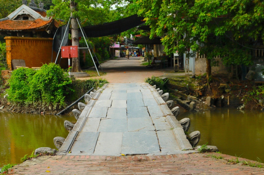 Cây cầu được làm hoàn toàn bằng 32 phiến đá xanh ghép khít lại với nhau, chia 9 nhịp, bắc ngang qua dòng Nguyệt Đức ở làng Nôm. cau-da-co-doc-nhat-vo-nhi-o-bac-bo-6.jpg