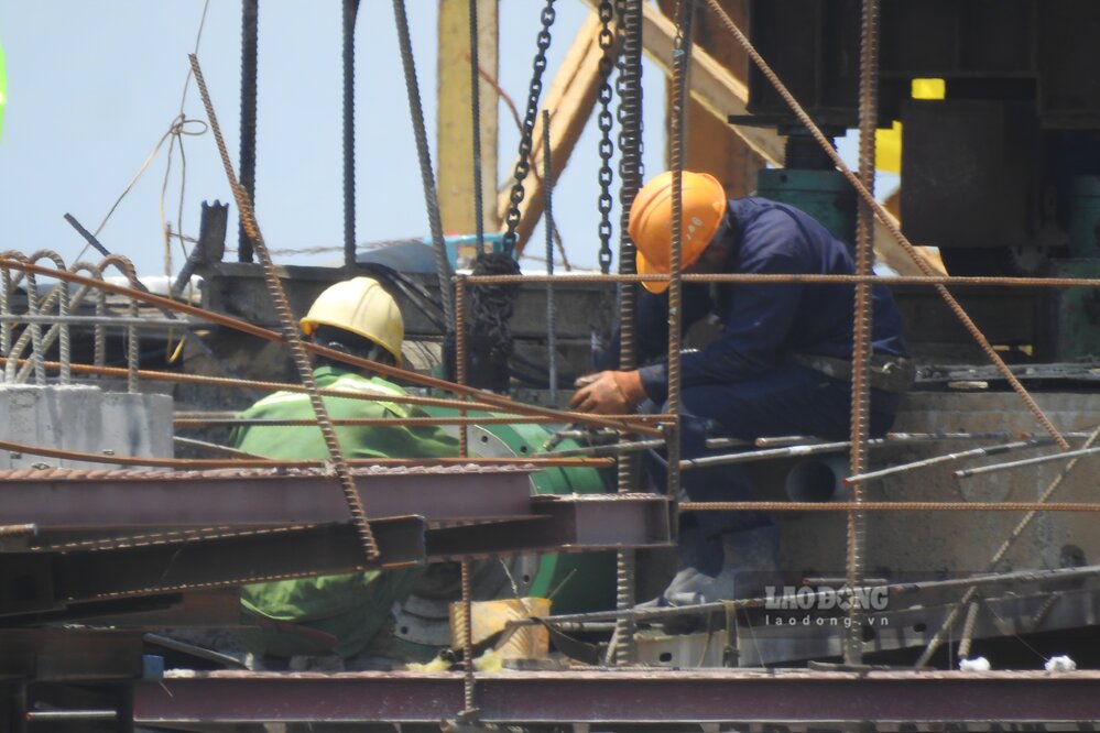 Các công nhân miệt mài thi công cầu dưới thời tiết nắng nóng oi bức. Ảnh: Tô Công.