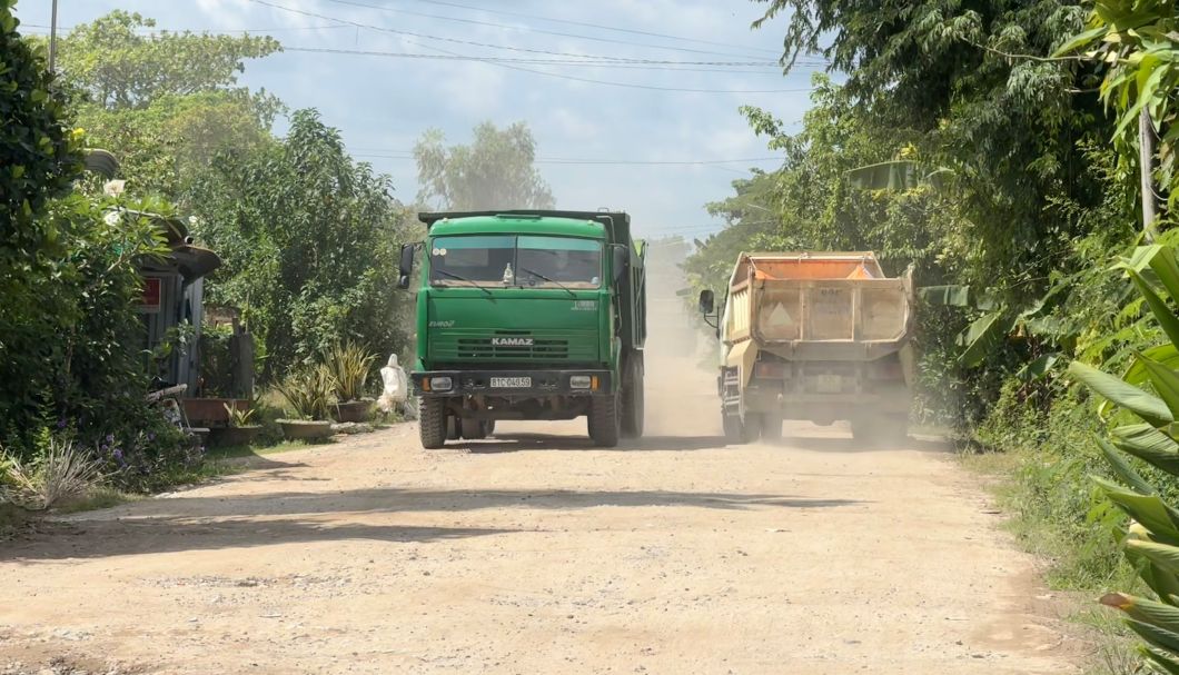 Mùa nắng, xe tải chạy qua làm bụi bay mù mịt, phủ trắng cả đoạn đường Bạch Đằng. Ảnh: Phương Anh