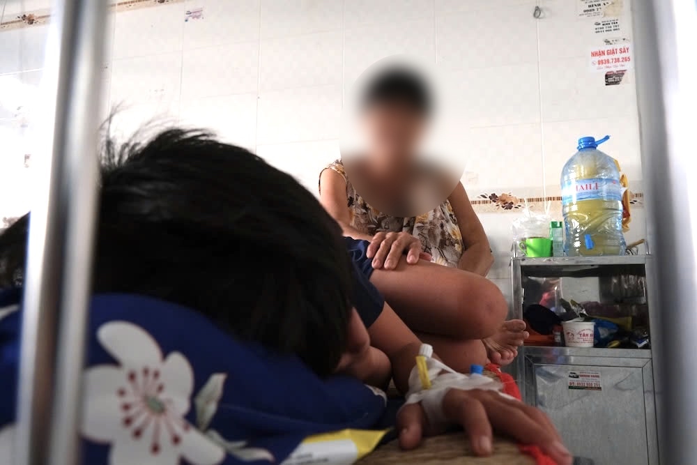 Bà Q chăm cháu bị sốt xuất huyết tại Bệnh viện Nhi đồng TP Cần Thơ. Ảnh: Phong Linh.