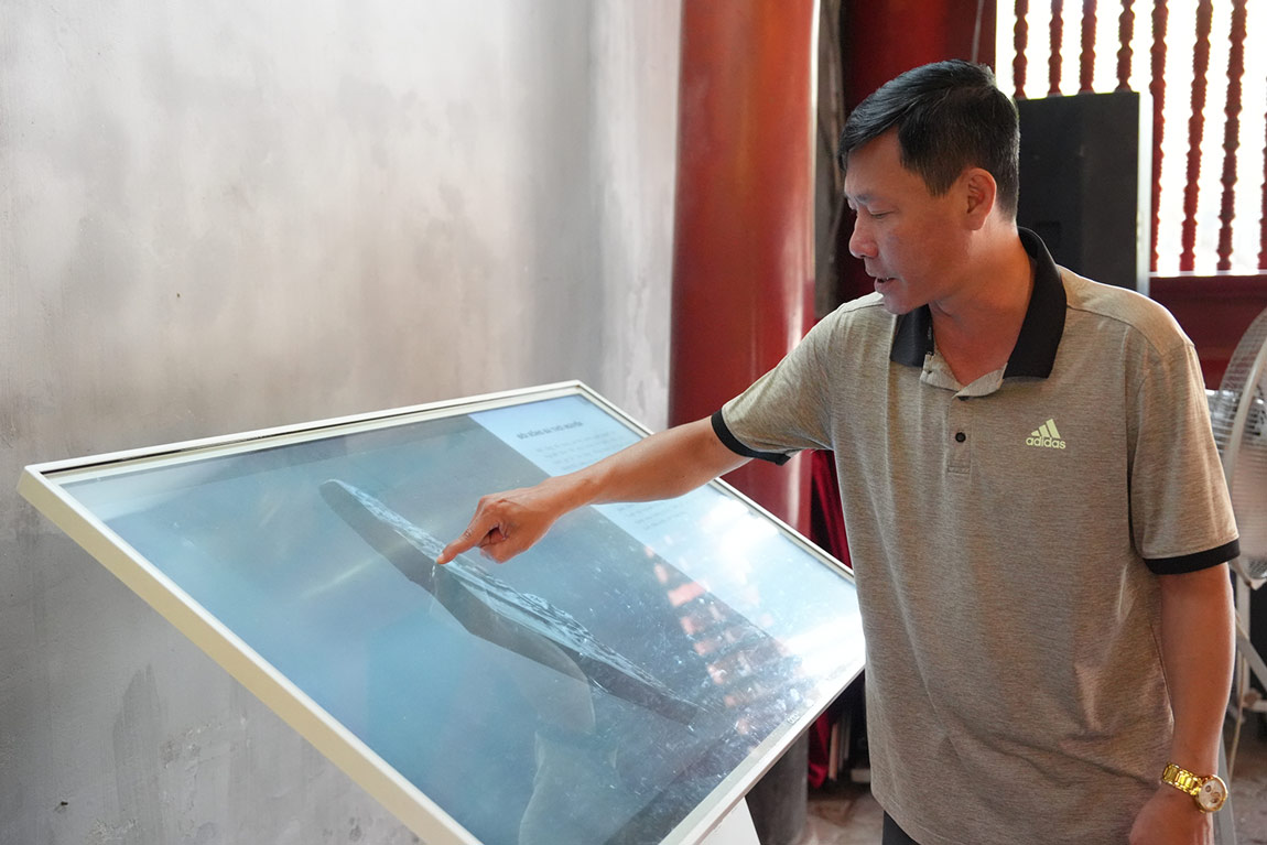 Ông Trần Xuân Hiến (phường Ba Đình, Hà Nội) trải nghiệm màn hình tương tác tại Văn Miếu - Quốc Tử Giám. Ảnh: Vũ Linh