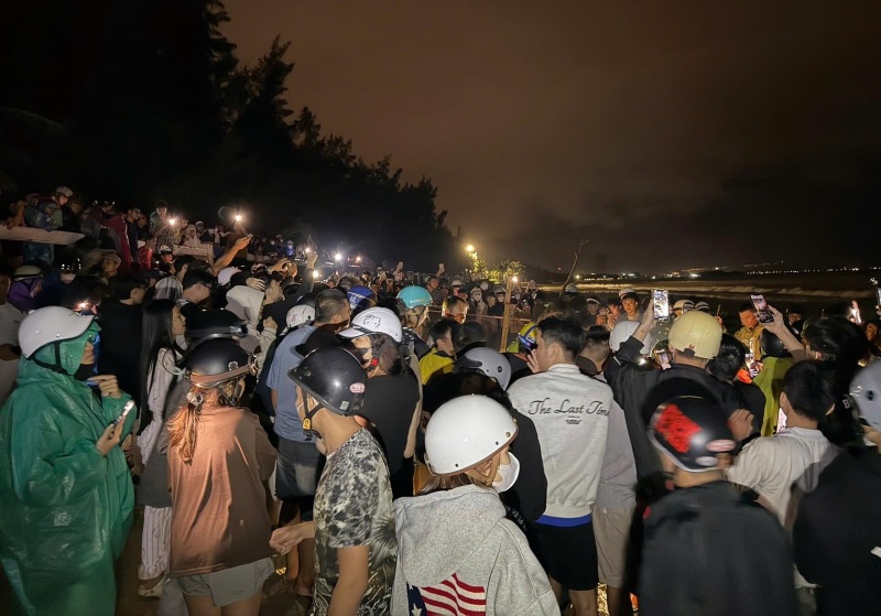 Cá voi khoảng 3m lụy vào bờ biển Đà Nẵng, thu hút rất đông người dân hiếu kỳ đến xem. Ảnh: Trường An