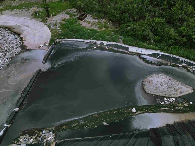 Nước thải từ bãi rác thung Quèn Khó chảy ra khu vực đường nội bộ bốc mùi hôi thối. Ảnh: Nguyễn Trường