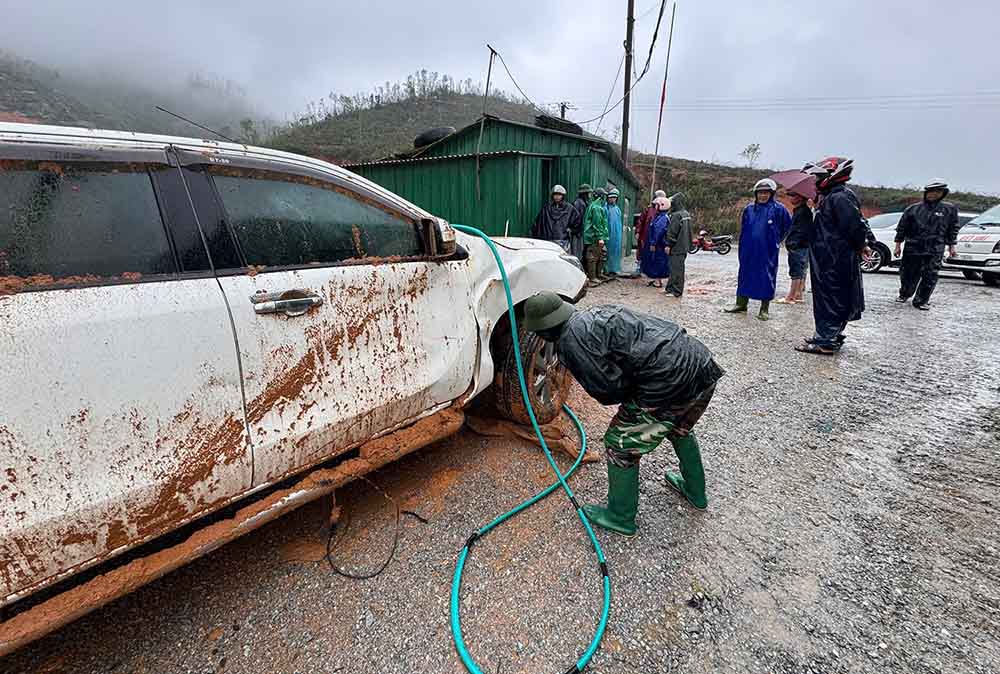 Một xe ô tô con hư hỏng do sạt lở. Ảnh: Trân Tuấn.