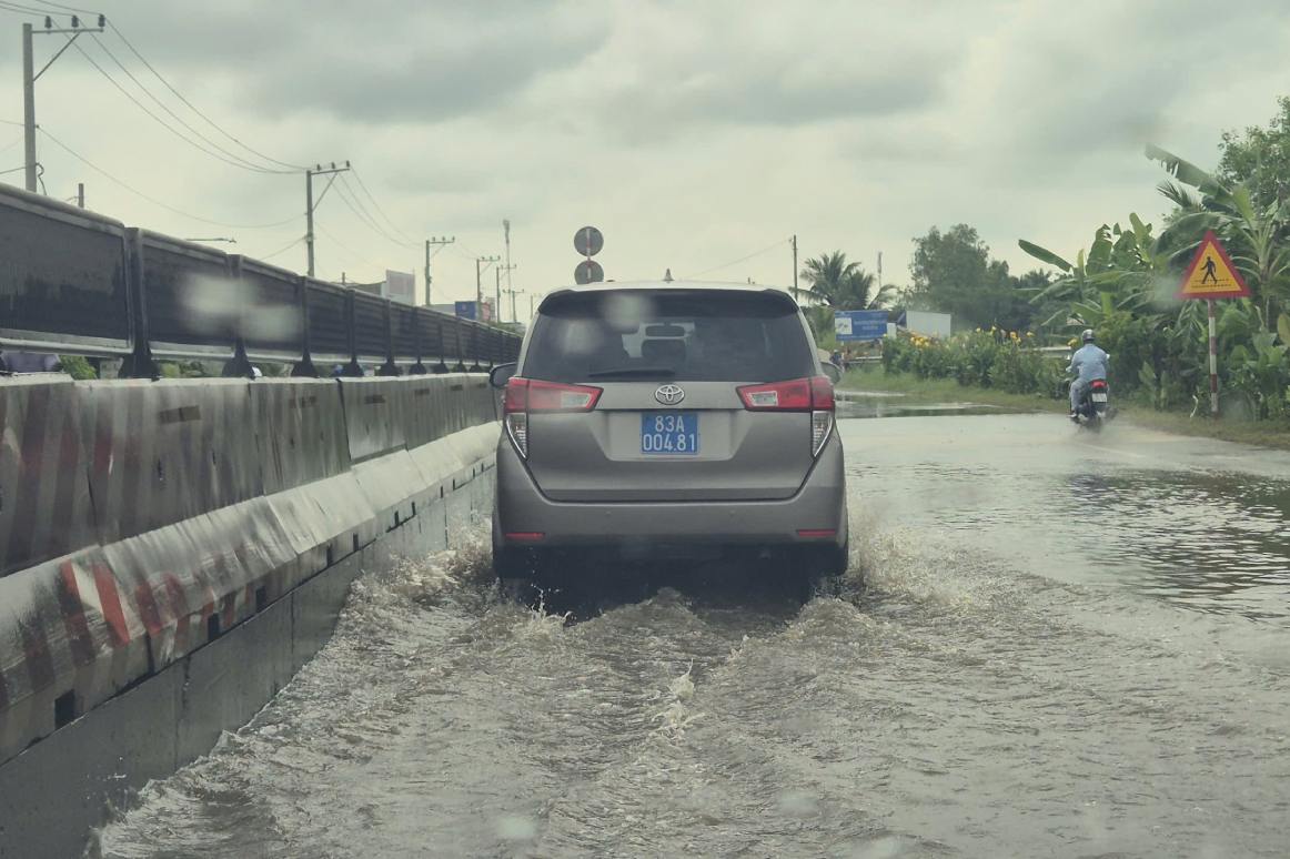 Triều cường và mưa dẫn đến Quốc lộ 1A bị ngập. Ảnh: Tạ Quang