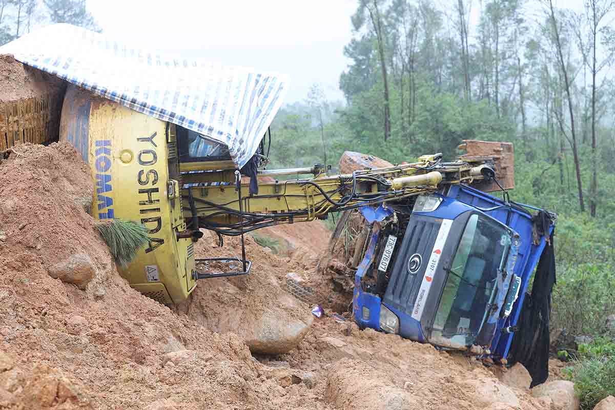 Chiều ngày 4.11, khi đang dọn đất đá thì sạt lở tiếp xô đổ máy đào và xe tải. Ảnh: Hoàng Anh.