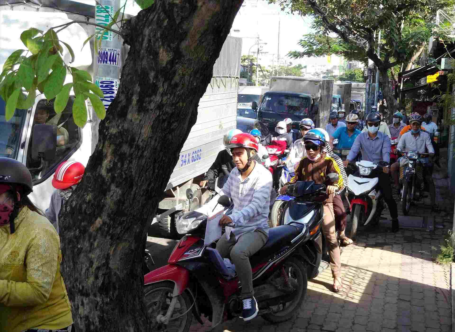 Xe máy nối đuôi nhau leo lên vỉa hè đường Đinh Bộ Lĩnh. Ảnh: Minh Quân