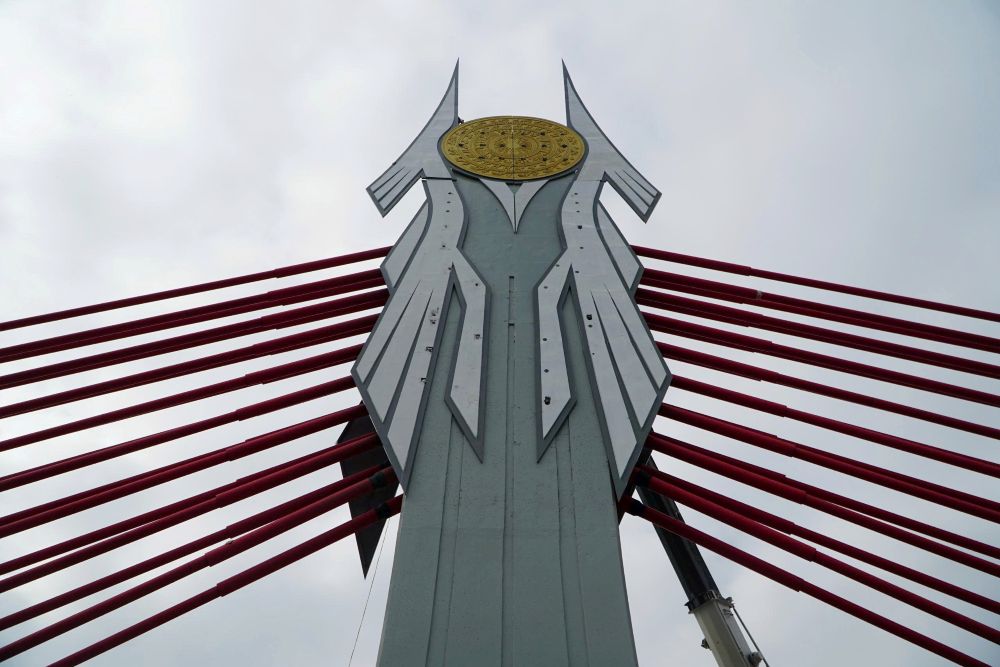 Trang trí, lắp đặt những họa tiết trên cầu dây văng. Ảnh: Quách Du