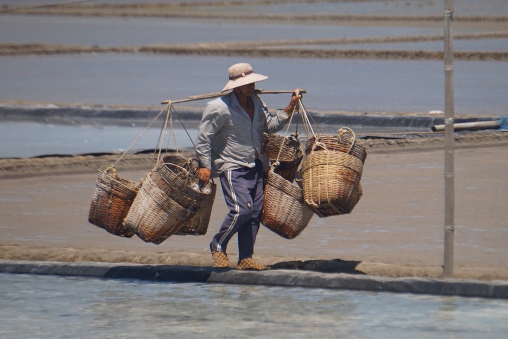 Diêm dân đội nắng thu hoạch muối giữa trưa. Ảnh: Thái Bảo