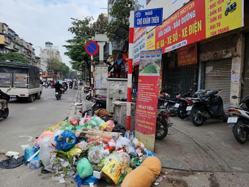 Rác ngập dưới chân biển cẩm đổ rác trên phố Khâm Thiên, Hà Nội. Ảnh: Minh Hạnh