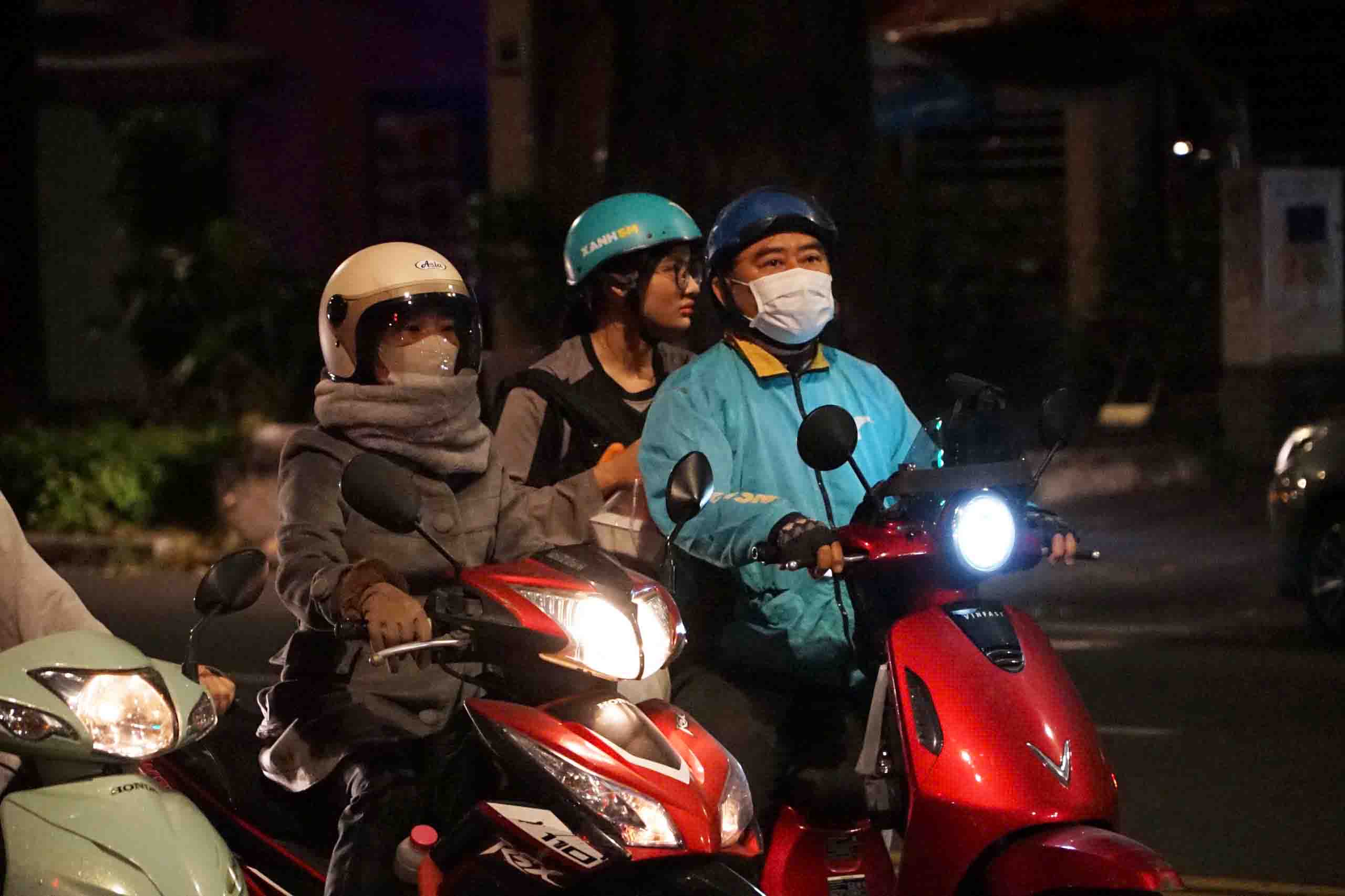 Người dân phải choàng thêm khăn dày khi chạy xe vào sáng sớm. Ảnh: Thái Bảo