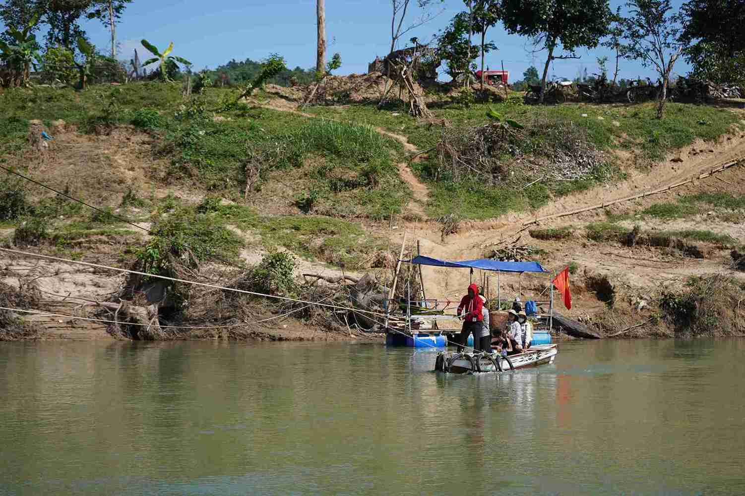 Cây khô, cỏ rác mắc lại trên dây cáp, cát bồi dày trắng xóa hai bên bờ sông.