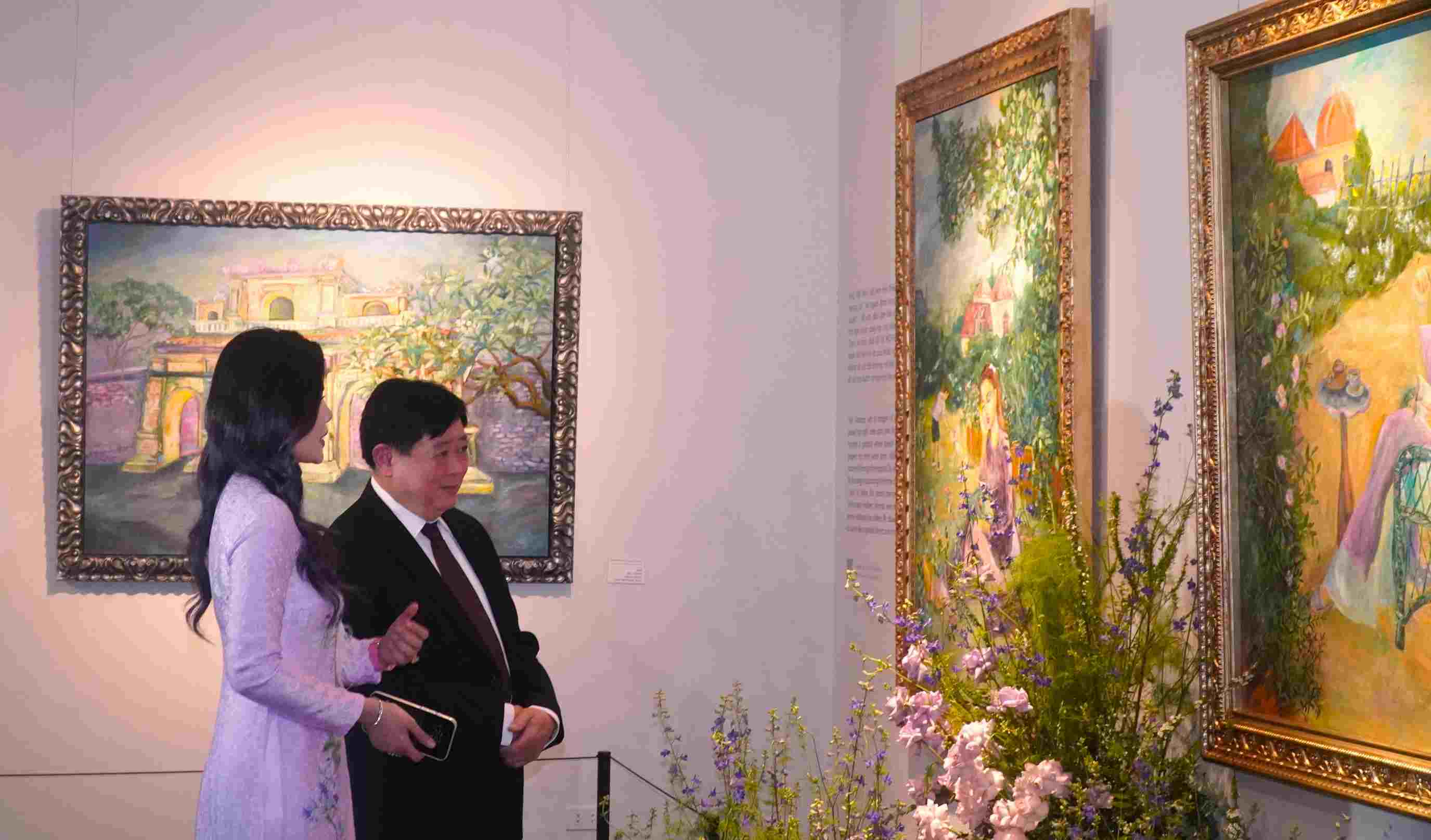 PGS.TS Nguyễn Thế Kỷ (bên phải), Phó Chủ tịch Hội đồng Lý luận Trung ương (kiêm Trưởng ban Lý luận phê bình văn học nghệ thuật) và họa sĩ Lê Trang (bên trái) thưởng lãm tranh tại không gian trưng bày tại Bảo tàng Mỹ thuật Việt Nam. Ảnh: Minh Vũ.