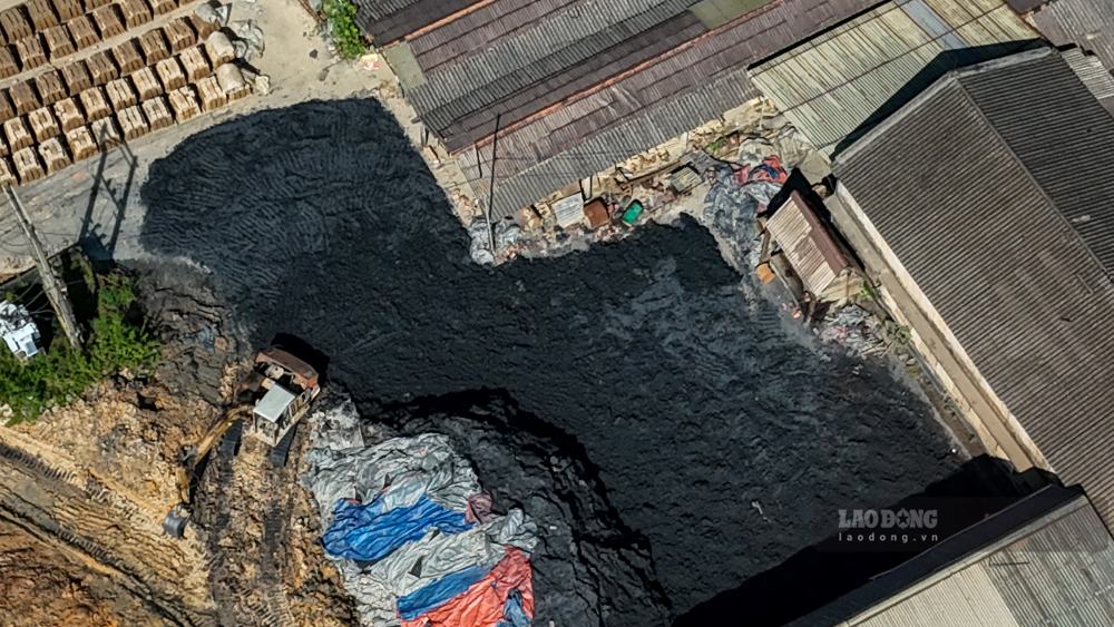 Vật liệu có màu đen được tập kết tràn lan, có nguy cơ thoát ra môi trường khi trời có mưa, gió. Ảnh: PV