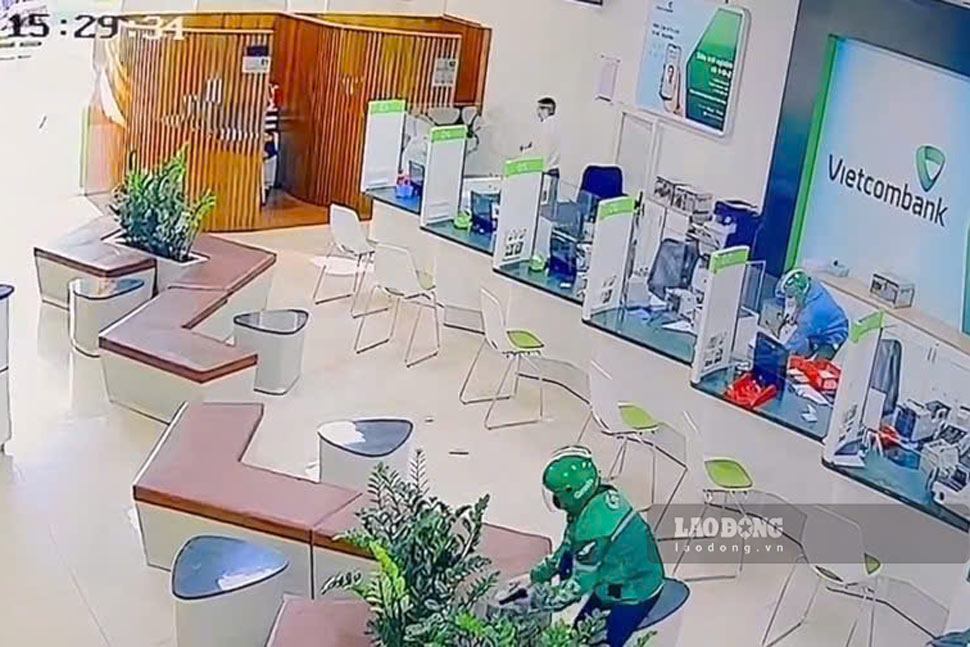 2 đối tượng cướp ngân hàng gom tiền vào ba lô rồi tẩu thoát. Ảnh: Hội Phú