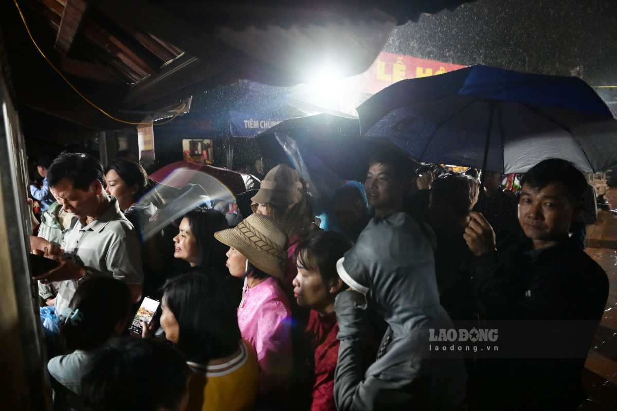 Đông kín người đội mưa, xếp hàng chờ xin lộc ấn đền Trần. Ảnh: Hà Vi