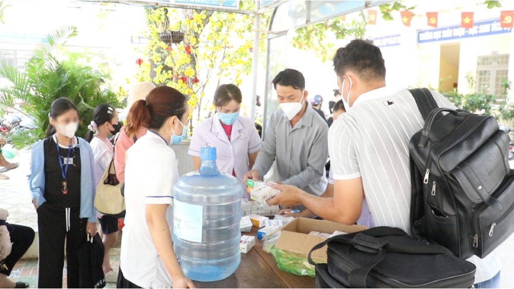 Phụ huynh đưa con em đến trường uống kháng sinh dự phòng. Ảnh: Nam Phương