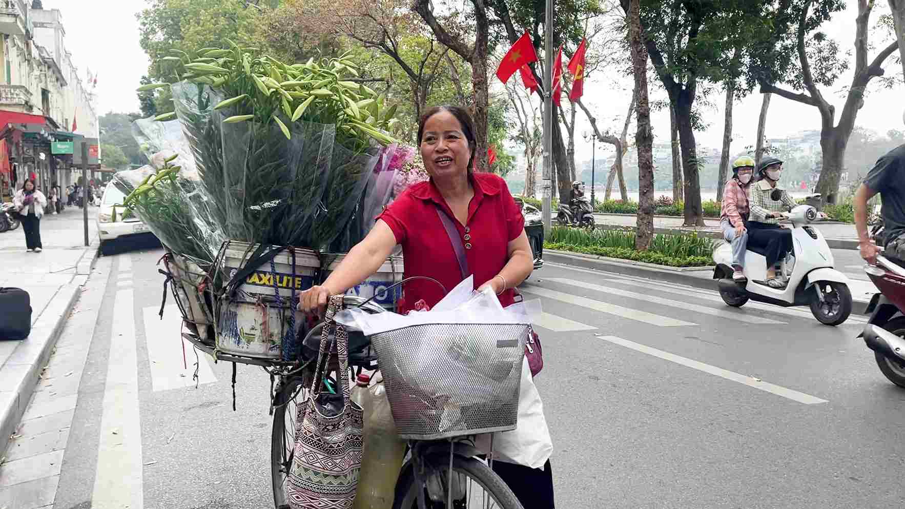 Bà Sáng dắt xe hoa bán dạo trên các con phố Hà Nội, mang theo sắc màu quen thuộc của phố cổ. Ảnh: Tạ Mai