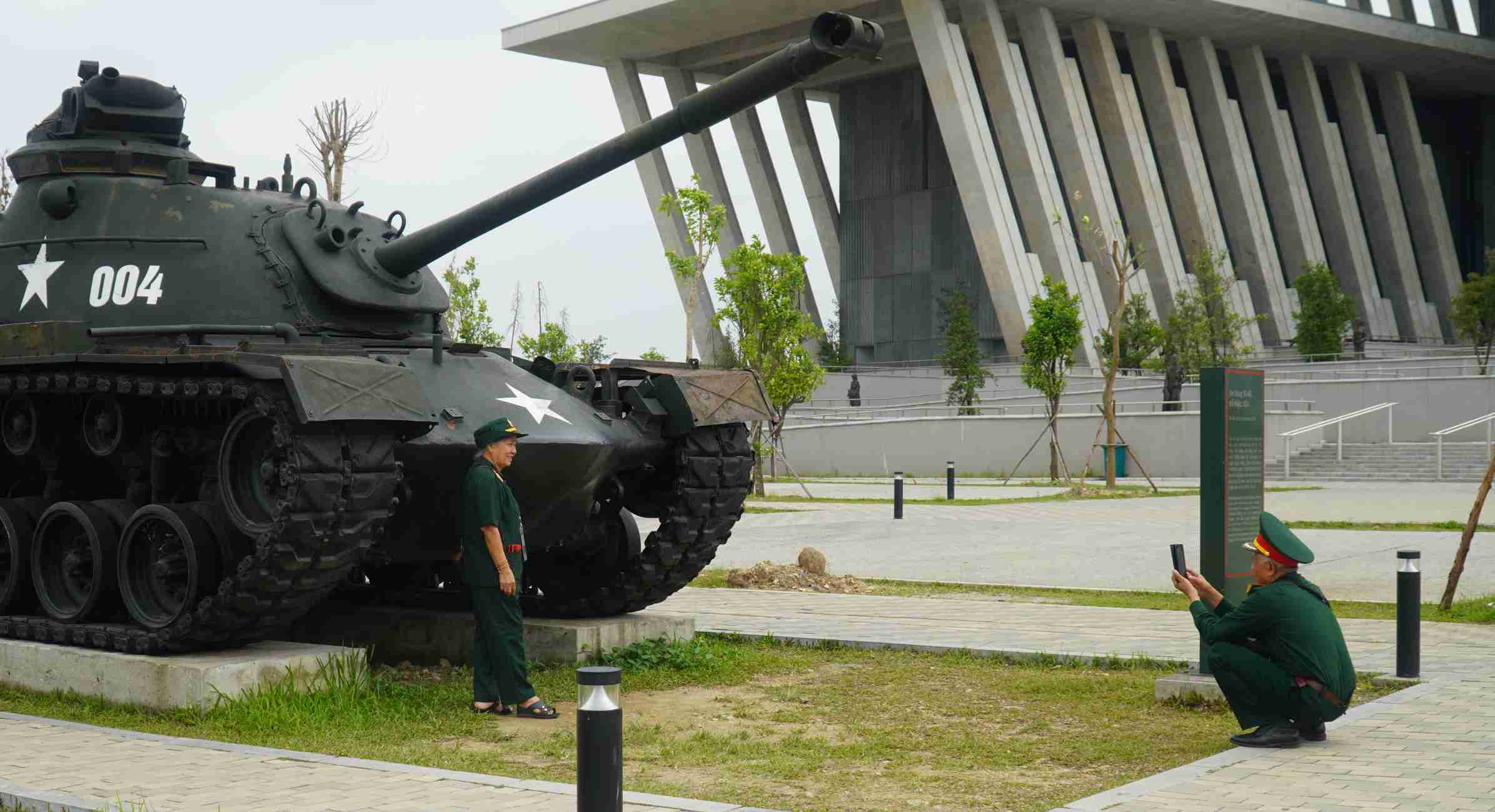 Cựu chiến binh chụp ảnh bên hiện vật tại Bảo tàng Lịch sử Quân sự Việt Nam.