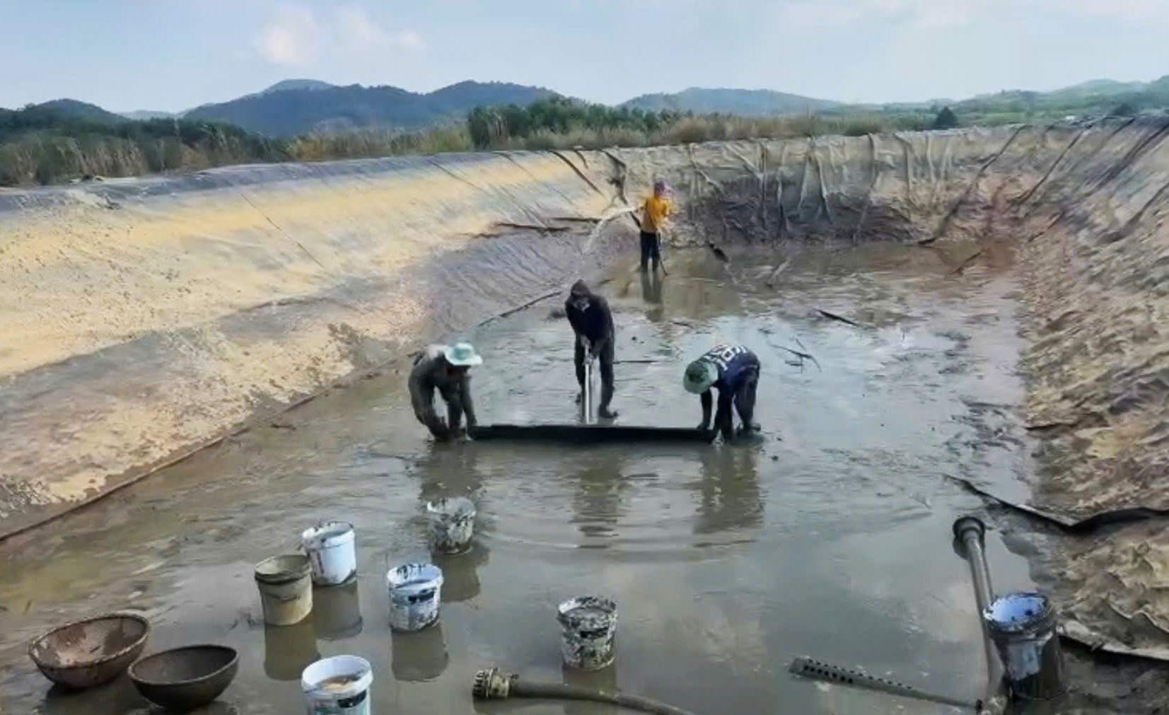 Gia đình ông Nguyễn Quang Việt vệ sinh hồ tích nước bơm từ suối Đạ Gùi. Ảnh: Phúc Khánh