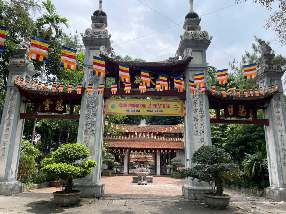 Cổng tam quan dẫn vào sân chùa có câu đối ghép bằng những mảnh sử màu xanh làm tăng thêm vẻ trang nghiêm cổ kính. Ảnh: I La